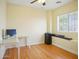 Bedroom with wood floors, a ceiling fan, desk, and a bright window at 14626 N 132Nd Ave, Surprise, AZ 85379