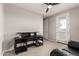 Bedroom with a ceiling fan, black desk, and a door leading to a balcony at 14727 W Pasadena Ave, Litchfield Park, AZ 85340