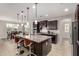 A kitchen featuring an island, dark cabinets, granite countertops, and stainless steel appliances at 14727 W Pasadena Ave, Litchfield Park, AZ 85340