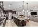 Kitchen with island and granite countertops, dark cabinets and stainless steel appliances at 14727 W Pasadena Ave, Litchfield Park, AZ 85340