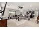 Open-concept living room with a large sectional sofa, a ceiling fan, and views into the kitchen at 14727 W Pasadena Ave, Litchfield Park, AZ 85340