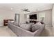 Bright living room with a large sectional sofa, ceiling fan, and plenty of natural light at 14727 W Pasadena Ave, Litchfield Park, AZ 85340