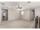 A large loft area with neutral carpet and a ceiling fan at 14727 W Pasadena Ave, Litchfield Park, AZ 85340