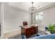 A home office is staged with a large wood desk, rug and a decorative light fixture at 14727 W Pasadena Ave, Litchfield Park, AZ 85340