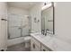 Bathroom featuring a vanity with marble countertop, dark faucet, framed mirror, and glass-enclosed shower at 1540 E Glencove St, Mesa, AZ 85203