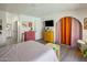 Comfortable bedroom featuring wood-look tile flooring, colorful decor, and arched doorways at 1540 E Glencove St, Mesa, AZ 85203