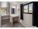 Bright bedroom vanity area with modern light fixture, view to pool, and light gray wood-look tile flooring at 1540 E Glencove St, Mesa, AZ 85203