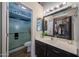 Bathroom with walk-in shower, single vanity, and decorative mirror at 16036 W Desert Bloom St, Goodyear, AZ 85338