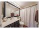 Full bathroom with dark cabinets, laminate floors, and neutral walls at 16036 W Desert Bloom St, Goodyear, AZ 85338