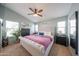 Spacious bedroom with a large bed, ceiling fan, and windows at 16036 W Desert Bloom St, Goodyear, AZ 85338