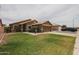Charming single-story home featuring a well-manicured lawn and desert landscaping at 16036 W Desert Bloom St, Goodyear, AZ 85338