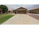 Driveway view of a two-car garage of a well-maintained, single-story home at 16036 W Desert Bloom St, Goodyear, AZ 85338
