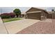 Single-story home featuring a long driveaway leading to a two-car garage at 16036 W Desert Bloom St, Goodyear, AZ 85338