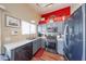 Well-lit kitchen featuring gray cabinets, stainless steel appliances, and a red accent wall at 16036 W Desert Bloom St, Goodyear, AZ 85338