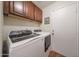 Laundry room with front-load washer and dryer and upper cabinets at 16036 W Desert Bloom St, Goodyear, AZ 85338