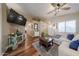 Cozy living room with hardwood floors, a ceiling fan, and neutral decor at 16036 W Desert Bloom St, Goodyear, AZ 85338