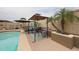 Poolside gazebo with barbecue and shaded seating offers a comfortable outdoor dining experience at 16036 W Desert Bloom St, Goodyear, AZ 85338