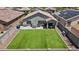 Aerial view of a backyard with artificial turf and a covered patio, perfect for outdoor entertaining at 17461 W Molly Ln, Surprise, AZ 85387