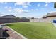 The manicured backyard features artificial turf, gravel accents, and a sturdy privacy wall at 17461 W Molly Ln, Surprise, AZ 85387