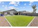 Spacious backyard with artificial turf, gravel accents, and a privacy wall for a low-maintenance outdoor space at 17461 W Molly Ln, Surprise, AZ 85387