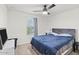 Bedroom with ceiling fan, plush carpet, and bright window offering plenty of natural light at 17461 W Molly Ln, Surprise, AZ 85387