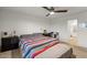 Cozy bedroom featuring carpet floors, a ceiling fan, and a view of the ensuite bath at 17461 W Molly Ln, Surprise, AZ 85387