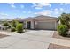 Charming single-story home with a two-car garage, covered porch, and desert landscaping at 17461 W Molly Ln, Surprise, AZ 85387
