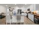 Well-lit kitchen features granite counters, an island with breakfast bar, and modern white cabinets at 17461 W Molly Ln, Surprise, AZ 85387