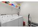 Spacious laundry room equipped with a washing machine, dryer, and overhead storage shelf at 17461 W Molly Ln, Surprise, AZ 85387
