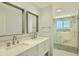 Contemporary bathroom featuring double sinks, modern fixtures, and a tiled glass-enclosed shower at 1930 E Missouri Ave, Phoenix, AZ 85016