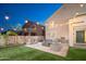 Outdoor living space featuring a stone fireplace, built-in grill and comfortable patio furniture under string lights at 22259 N 102Nd Ln, Peoria, AZ 85383