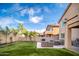 Inviting backyard featuring a manicured lawn, a built-in grill, a fire pit and comfortable seating at 22259 N 102Nd Ln, Peoria, AZ 85383