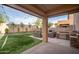Inviting backyard featuring a built-in grill, fireplace, patio, and seating under string lights at 22259 N 102Nd Ln, Peoria, AZ 85383