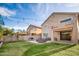 Spacious backyard featuring a cozy outdoor lounge, fireplace, and manicured lawn at 22259 N 102Nd Ln, Peoria, AZ 85383