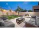 Relaxing backyard with a stone fireplace and plush outdoor seating, perfect for entertaining at 22259 N 102Nd Ln, Peoria, AZ 85383