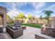 Spacious backyard featuring plush seating around an outdoor fireplace at 22259 N 102Nd Ln, Peoria, AZ 85383