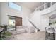 Bright living room featuring a sectional sofa, a barn door, and a staircase leading to the second floor at 22259 N 102Nd Ln, Peoria, AZ 85383