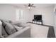 Comfortable living room setup with a plush sectional and an ottoman, accented by a stylish ceiling fan at 22259 N 102Nd Ln, Peoria, AZ 85383