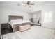 Tranquil main bedroom with a rustic wood bed frame, ceiling fan, and cozy seating area at 22259 N 102Nd Ln, Peoria, AZ 85383