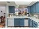 Open kitchen with stainless steel appliances, neutral countertops, and views into the living area at 2326 E Evans Dr, Phoenix, AZ 85022