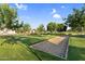 Bocce ball court in a community park with green grass, lush trees, and manicured landscaping at 24138 S 220Th St, Queen Creek, AZ 85142
