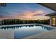 Backyard pool featuring travertine decking and desert landscaping under a sunset sky at 24138 S 220Th St, Queen Creek, AZ 85142