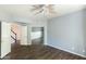 Open bedroom with wood-look floors, a ceiling fan, and mirrored closet doors at 2709 E Vista Dr, Phoenix, AZ 85032