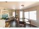 Open-concept dining area with a glass table, modern lighting, and a cozy living space at 2709 E Vista Dr, Phoenix, AZ 85032