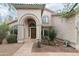 Inviting front entrance with an arched doorway, tiled roof, and desert-style landscaping at 2709 E Vista Dr, Phoenix, AZ 85032