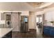 Bright kitchen with stainless steel appliances, quartz countertops, and a sliding barn door at 2709 E Vista Dr, Phoenix, AZ 85032