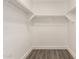 Walk-in closet with white shelves and gray wood-look floors at 2710 S Shelby --, Mesa, AZ 85209