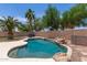 Inviting pool with rock waterfall feature, mature palms and lush green trees create a relaxing backyard oasis at 2710 S Shelby --, Mesa, AZ 85209