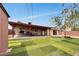 Large backyard with patio featuring artificial turf, barbecue area, and mature landscaping at 2907 W Townley Ave, Phoenix, AZ 85051