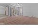 Bright living room area with wall-to-wall carpet, a ceiling fan and lots of natural light coming through sliding glass doors at 2916 S Revere Cir, Mesa, AZ 85210